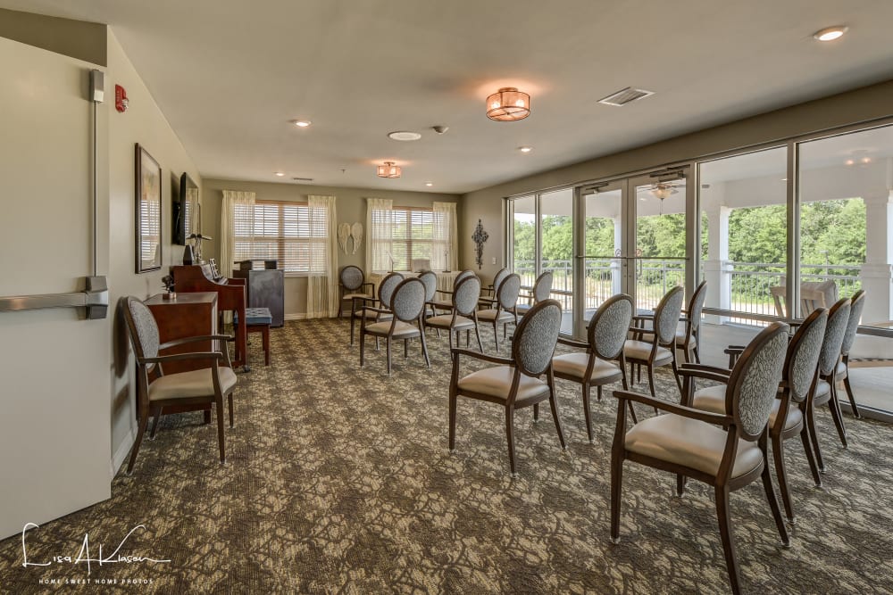 A spacious room featuring several chairs arranged around a large television